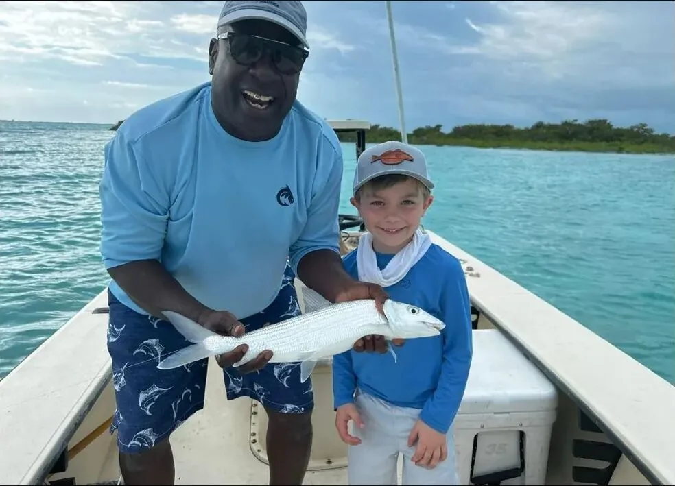 JJ Dames and a young guest holding a bonefish on the boat