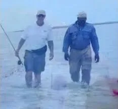 Two anglers wading together on a shallow Exuma flat